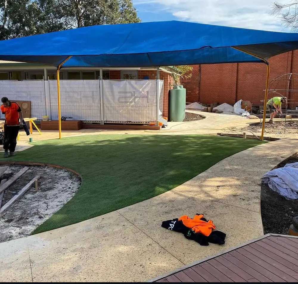 Commercial synthetic turf installation at a childcare centre under shade sail structure